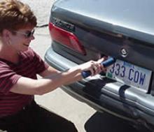 Seller is removing a license plate.