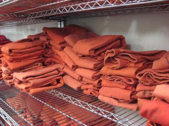 Shelf of folded standard issue jail clothing.