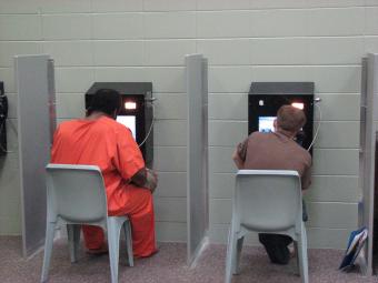 Inmates on the video conference with counterparts in the visitation room.