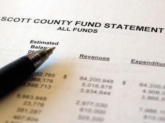 Image of pen over set of miscellaneous accounting figures.