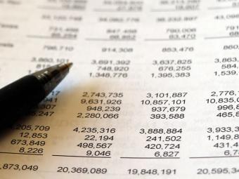 Closeup of a pen over non descript table of numbers.