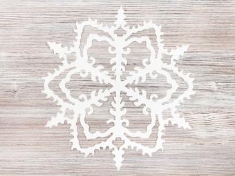 white paper snowflake on grey/light brown background