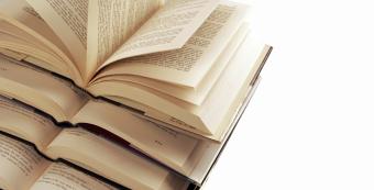 open book on top of stack of books isolated on white background