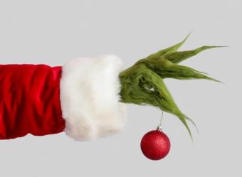 grinch hand holding a red ornament
