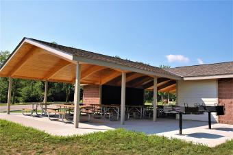 Side view of picnic shelter with two charcoal grills.