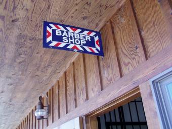 Barber shop sign hangs outside the door.