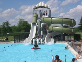 Swimmers having fun at the water slide at Scott County Park Pool.