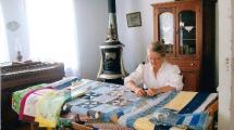 A woman quilting in one of the historic buildings.